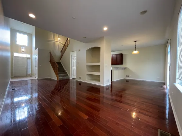 a view of a livingroom with wooden floor and staircase