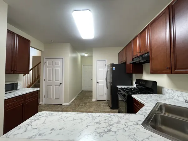 a kitchen with stainless steel appliances granite countertop a stove a sink and a refrigerator