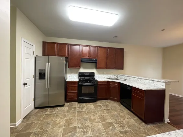a kitchen with granite countertop a sink stove and refrigerator