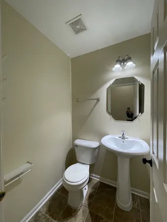 a bathroom with a toilet sink and mirror