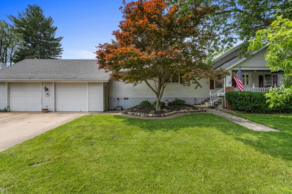 a view of a house with backyard and a tree