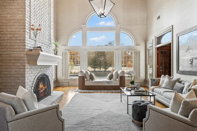 a living room with furniture a fireplace and a chandelier