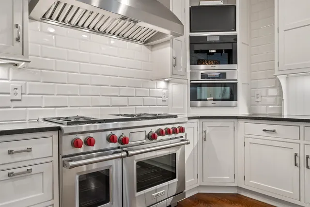 a stove top oven sitting inside of a kitchen