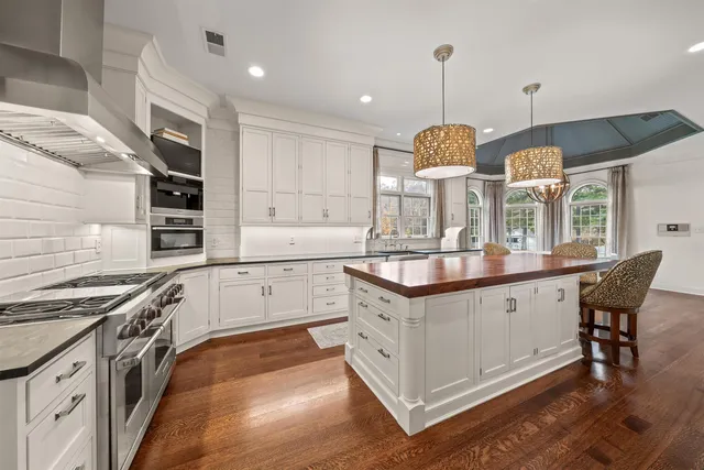 a kitchen with stainless steel appliances granite countertop a stove a sink and a wooden floors