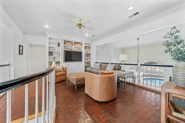 a living room with couches a flat screen tv and kitchen view