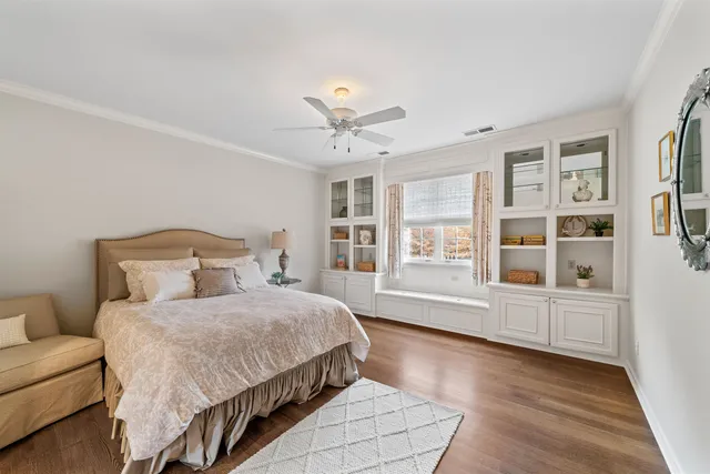 a bedroom with a large bed wooden floor and window
