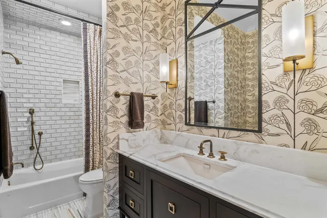 a bathroom with a granite countertop sink a toilet and a mirror