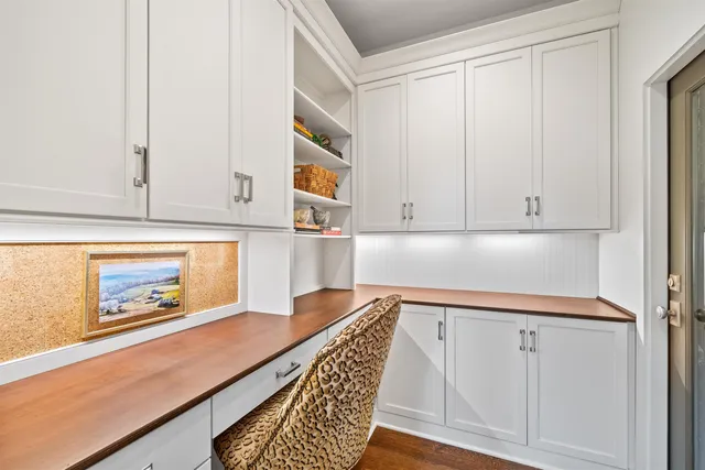 a kitchen with white cabinets and wooden floor
