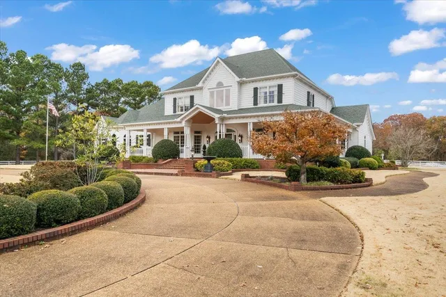 a front view of a house with a yard and potted plants