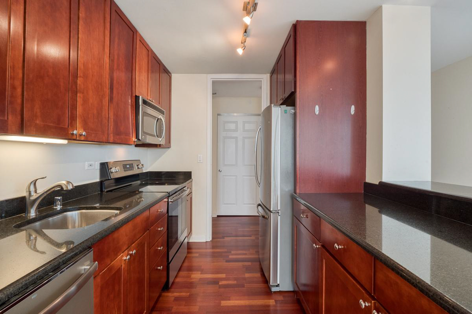 655 West Irving Park Road, Unit 1502 Chicago, IL 60613 - Photo 4 of 24 a kitchen with granite countertop stainless steel appliances a sink stove and cabinets