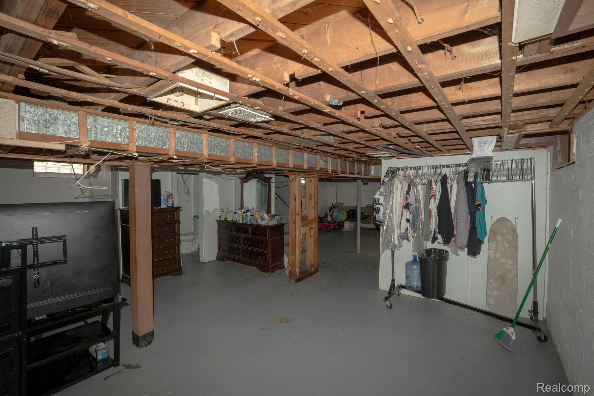 16821 East Eight Mile Road Eastpointe, MI 48021 - Photo 22 of 31 Unfinished basement space with exposed wood joists and a concrete floor