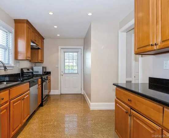 a kitchen with stainless steel appliances granite countertop a sink a stove and a refrigerator