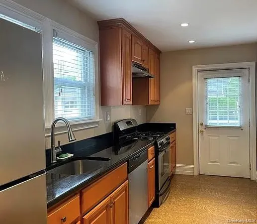 a kitchen with stainless steel appliances granite countertop a sink stove and cabinets
