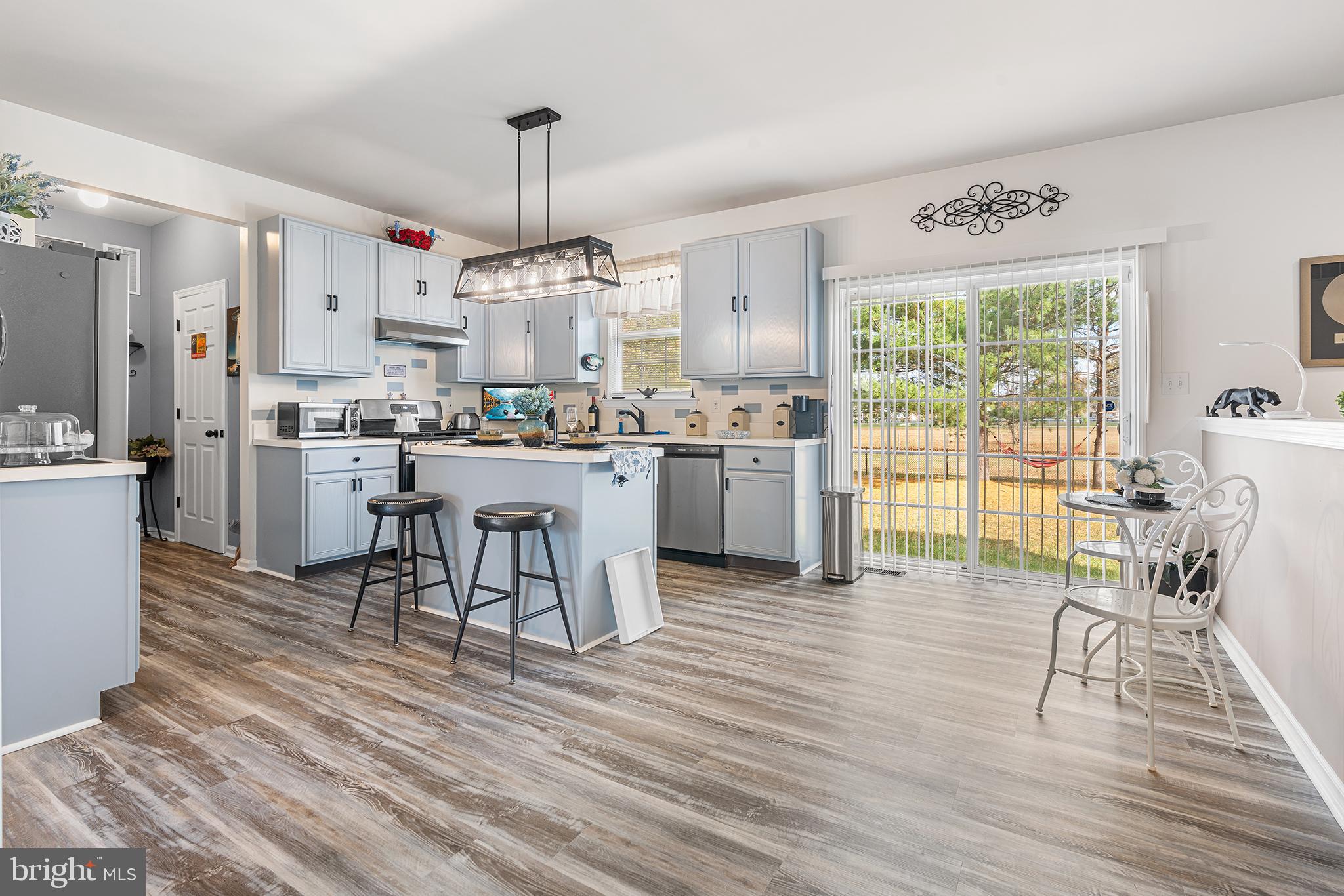 19 Howard Street Carneys Point, NJ 08069 - Photo 13 of 39 a kitchen with stainless steel appliances granite countertop a stove top oven a dining table and chairs with wooden floor