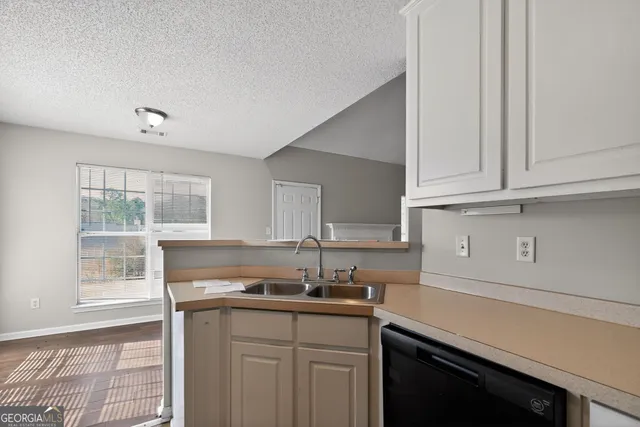 a kitchen with stainless steel appliances granite countertop a sink and a white cabinets