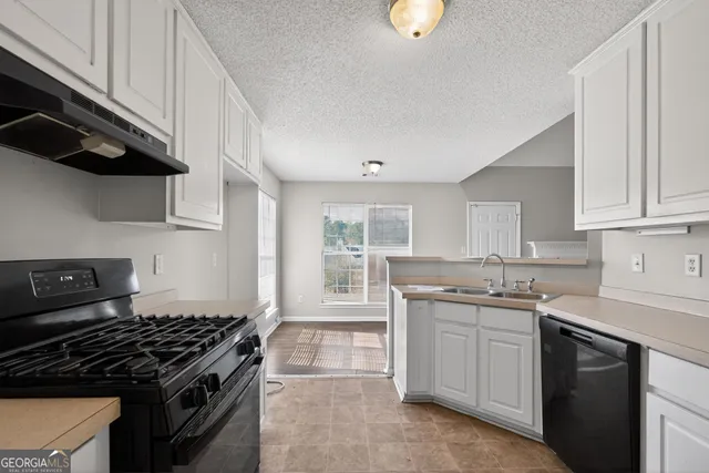 a kitchen with white cabinets and appliances