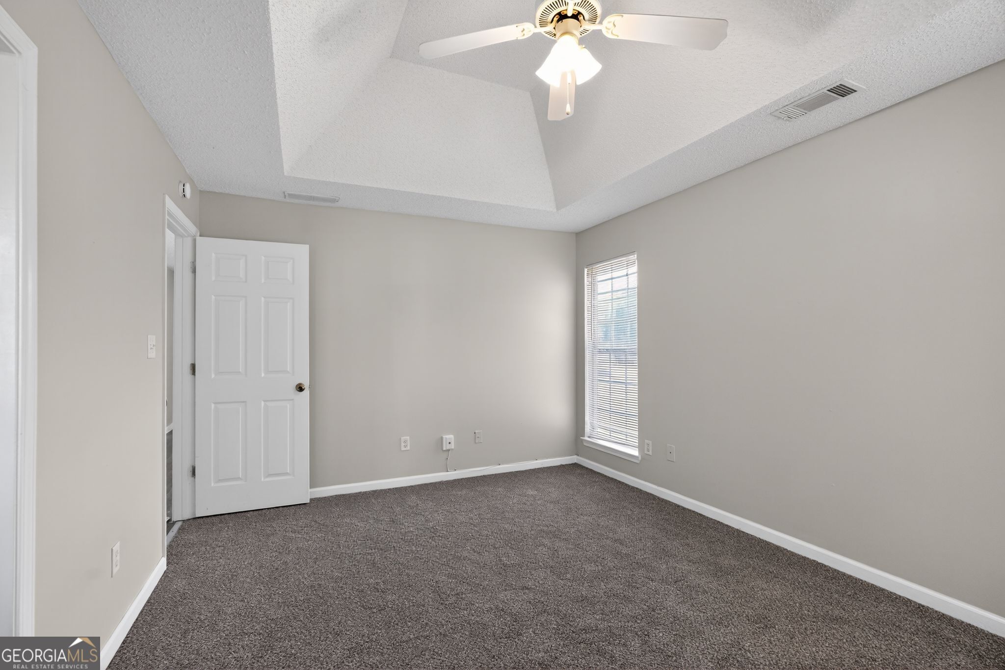 4708 Golod Way Lithonia, GA 30038 - Photo 17 of 33 an empty room with a chandelier fan and windows