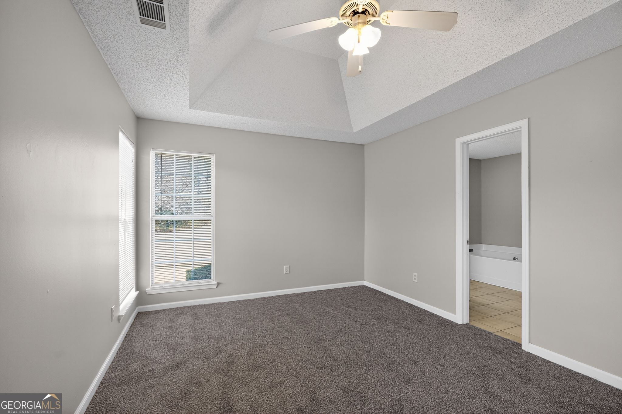 4708 Golod Way Lithonia, GA 30038 - Photo 19 of 33 an empty room with windows and fan