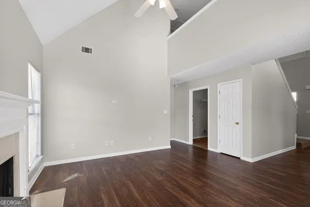 an empty room with wooden floor and a fireplace