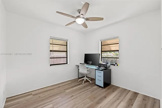 a workspace with wooden floor and a window