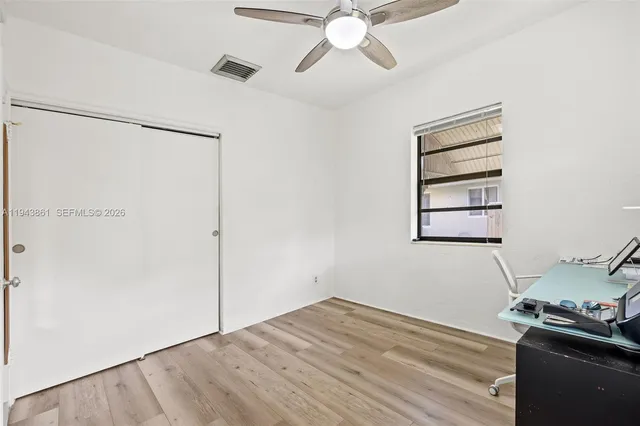 a view of a room with wooden floor and ceiling fan