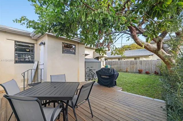 a view of a backyard with table and chairs and wooden fence