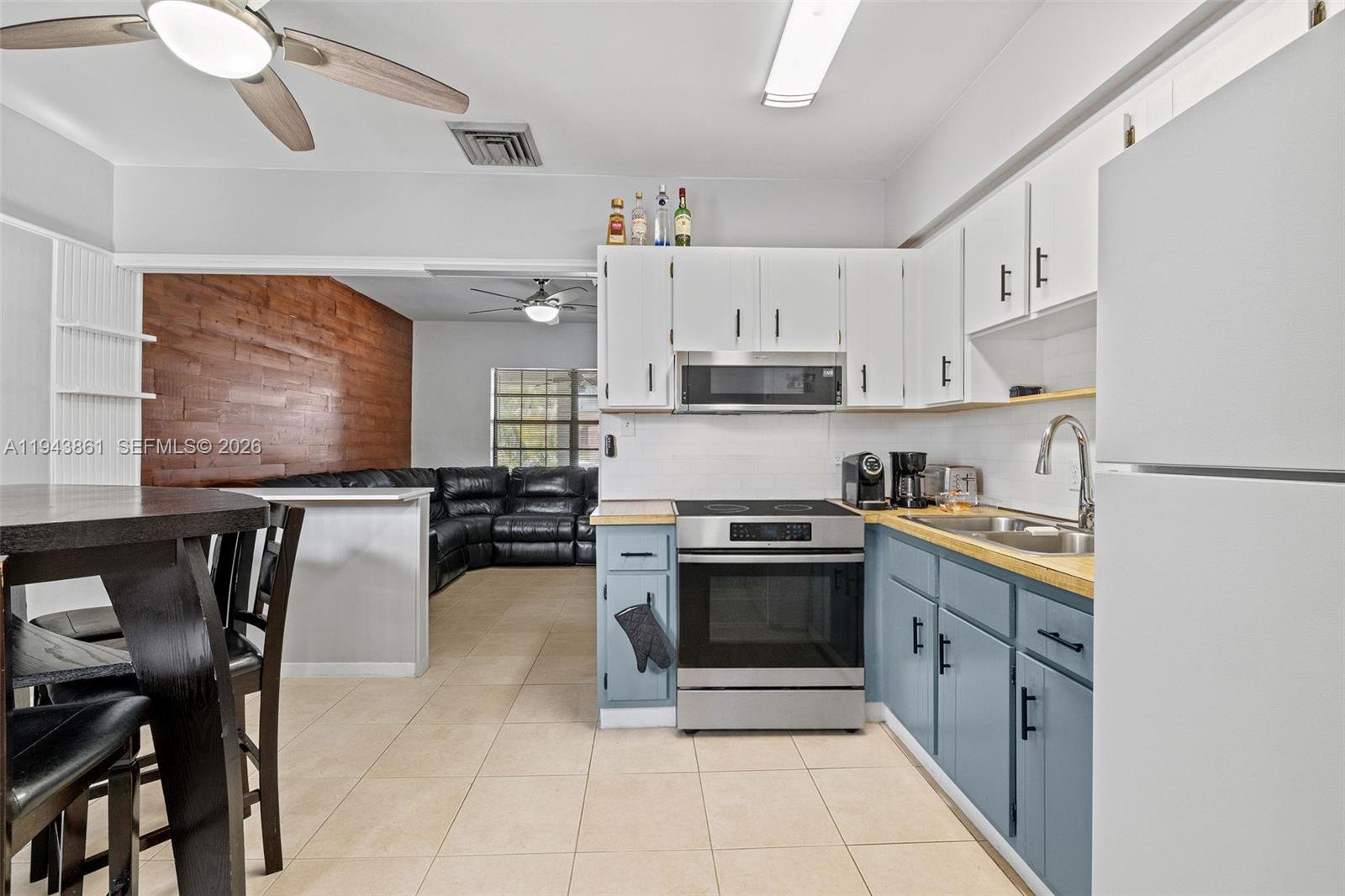 206 Southeast 5th Street Dania Beach, FL 33004 - Photo 7 of 26 a kitchen with stainless steel appliances granite countertop a stove top oven a sink a dining table and chairs