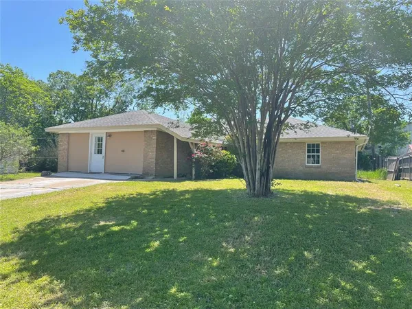 a view of a house with backyard and a tree
