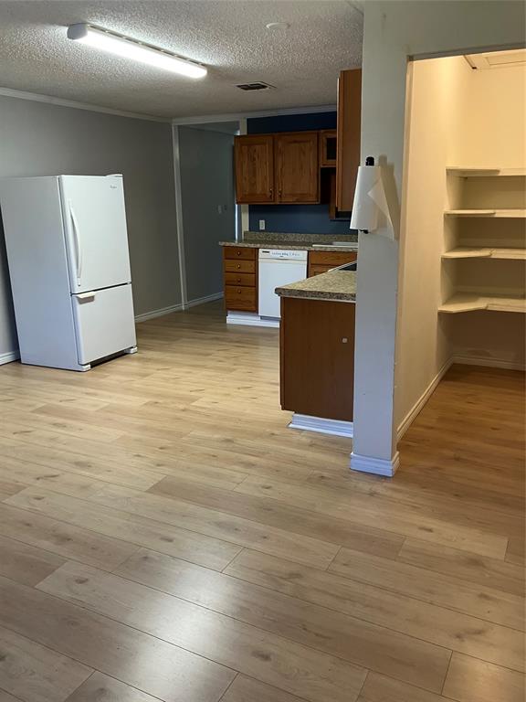 717 Bluebonnet Street Mexia, TX 76667 - Photo 14 of 25 a view of kitchen with microwave refrigerator and wooden floor