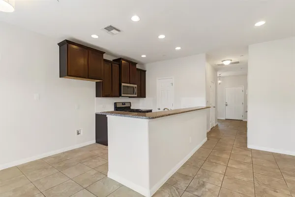 a kitchen with kitchen island granite countertop a stove and a sink
