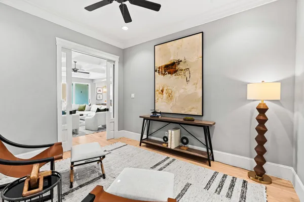 a living room with furniture kitchen view and a wooden floor