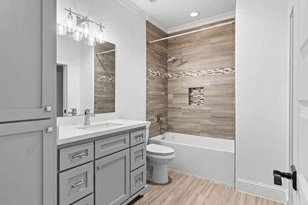 a bathroom with a double vanity sink toilet mirror and shower