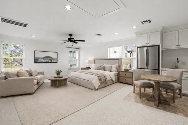 a spacious bedroom with a bed a couch and a large window