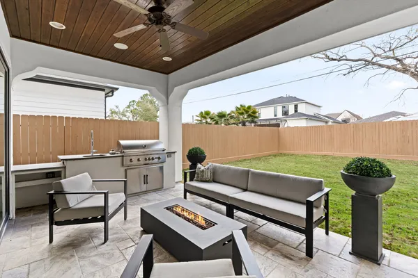 a living room with patio furniture and a potted plant