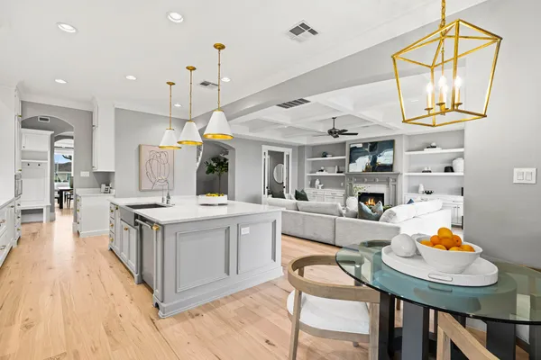 a kitchen with stainless steel appliances granite countertop a sink a stove a refrigerator and chairs