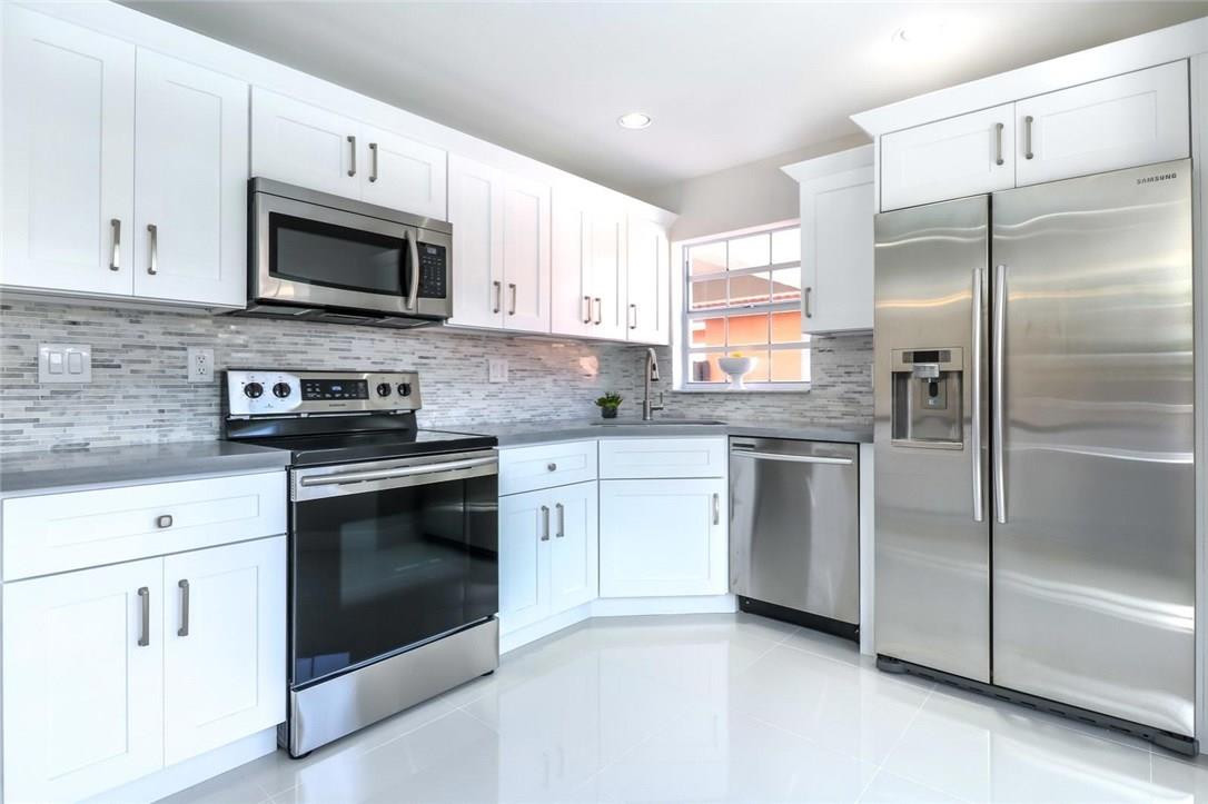8237 Northwest 200th Terrace Hialeah, FL 33015 - Photo 11 of 30 a kitchen with white cabinets stainless steel appliances and sink