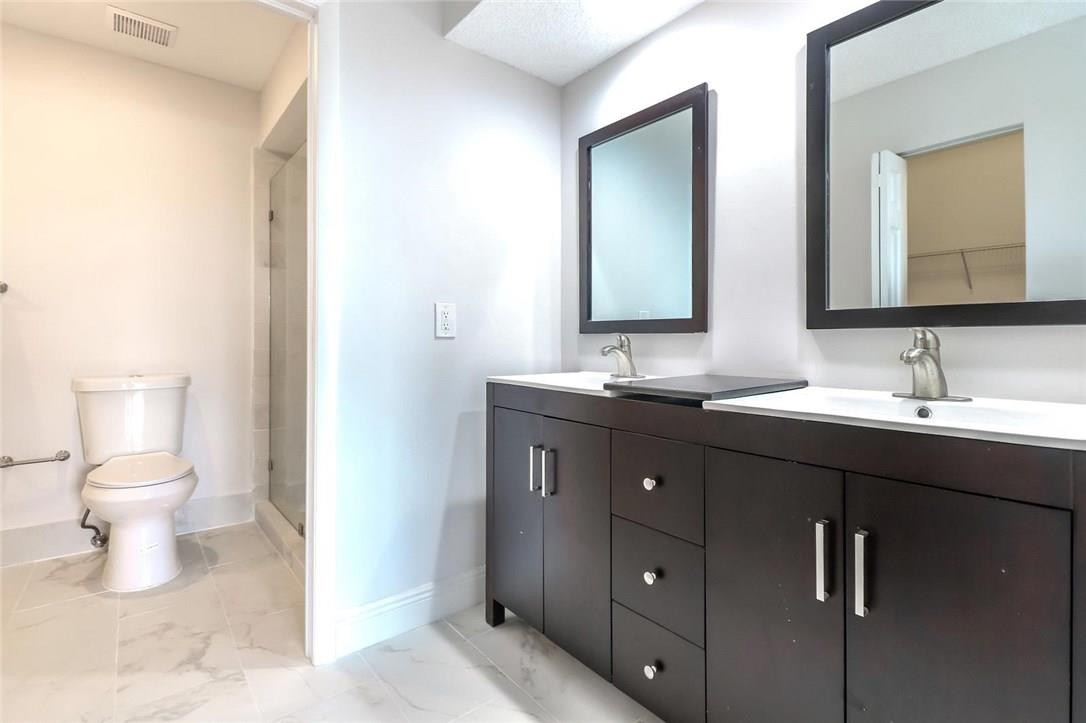 8237 Northwest 200th Terrace Hialeah, FL 33015 - Photo 17 of 30 a bathroom with a double vanity sink and a toilet