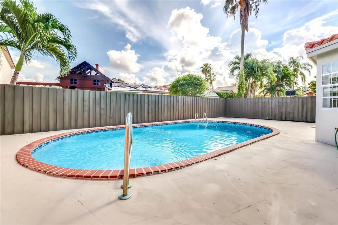 8237 Northwest 200th Terrace Hialeah, FL 33015 - Photo 2 of 30 a view of a swimming pool with a patio and a yard