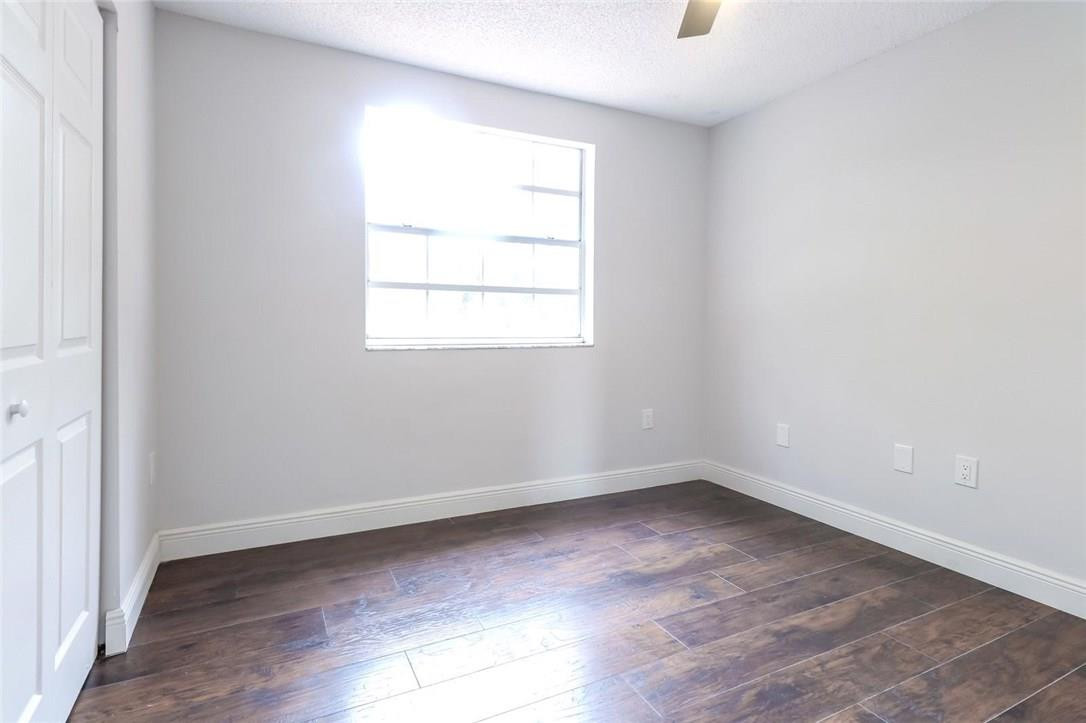 8237 Northwest 200th Terrace Hialeah, FL 33015 - Photo 24 of 30 an empty room with wooden floor and windows
