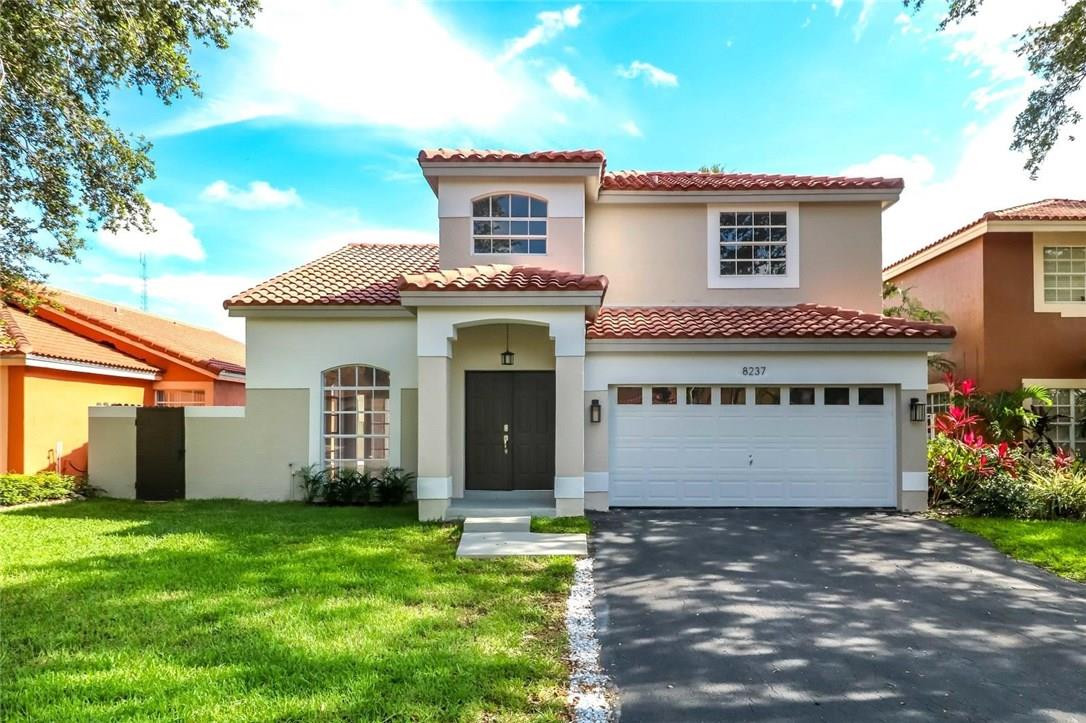 8237 Northwest 200th Terrace Hialeah, FL 33015 - Photo 3 of 30 a view of a house with yard and a garden