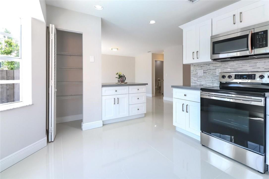 8237 Northwest 200th Terrace Hialeah, FL 33015 - Photo 10 of 30 a kitchen with stainless steel appliances granite countertop a stove a microwave and a refrigerator
