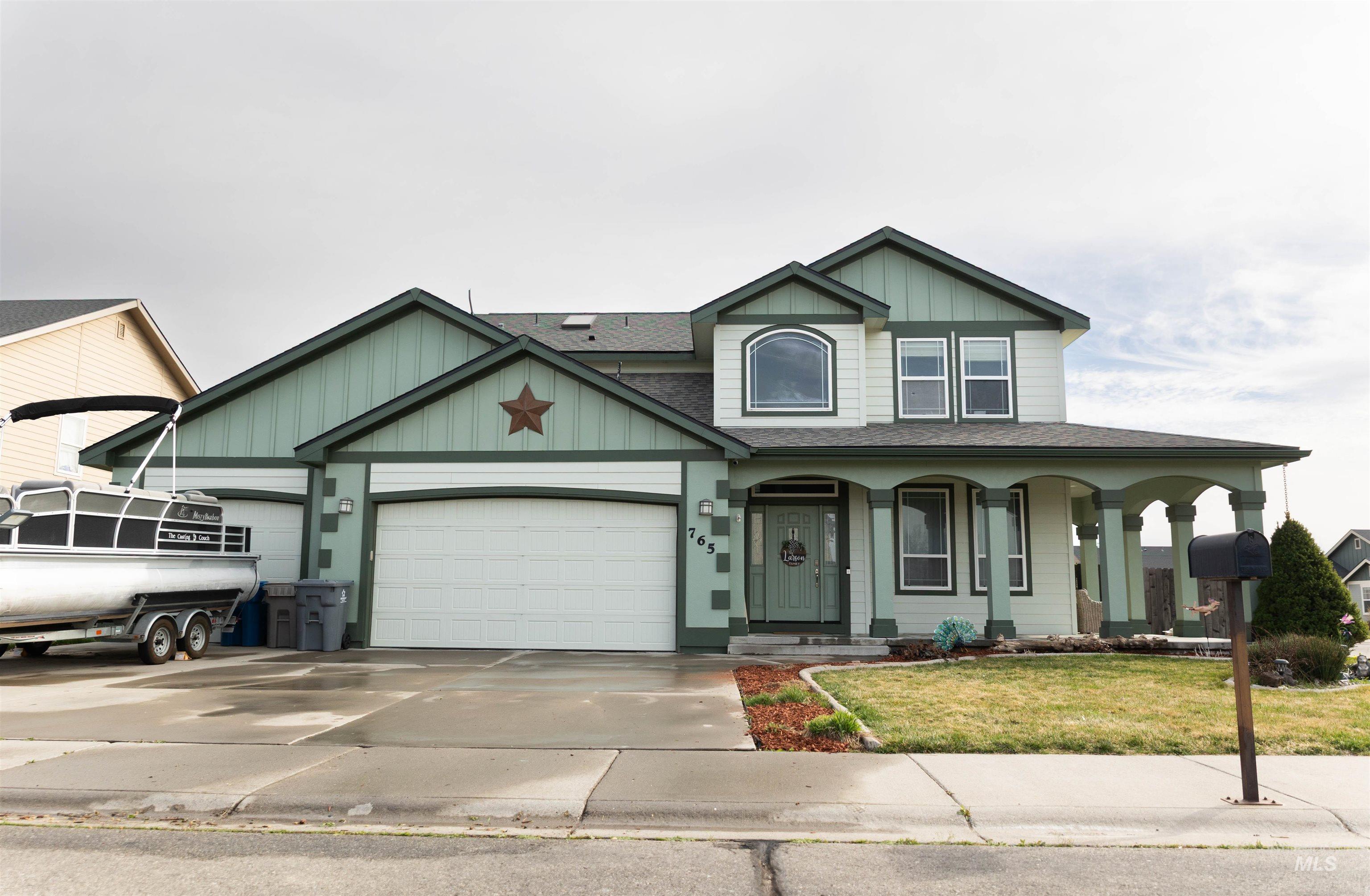 View of front of home with a porch, a garage, a front lawn, and roof with shingles