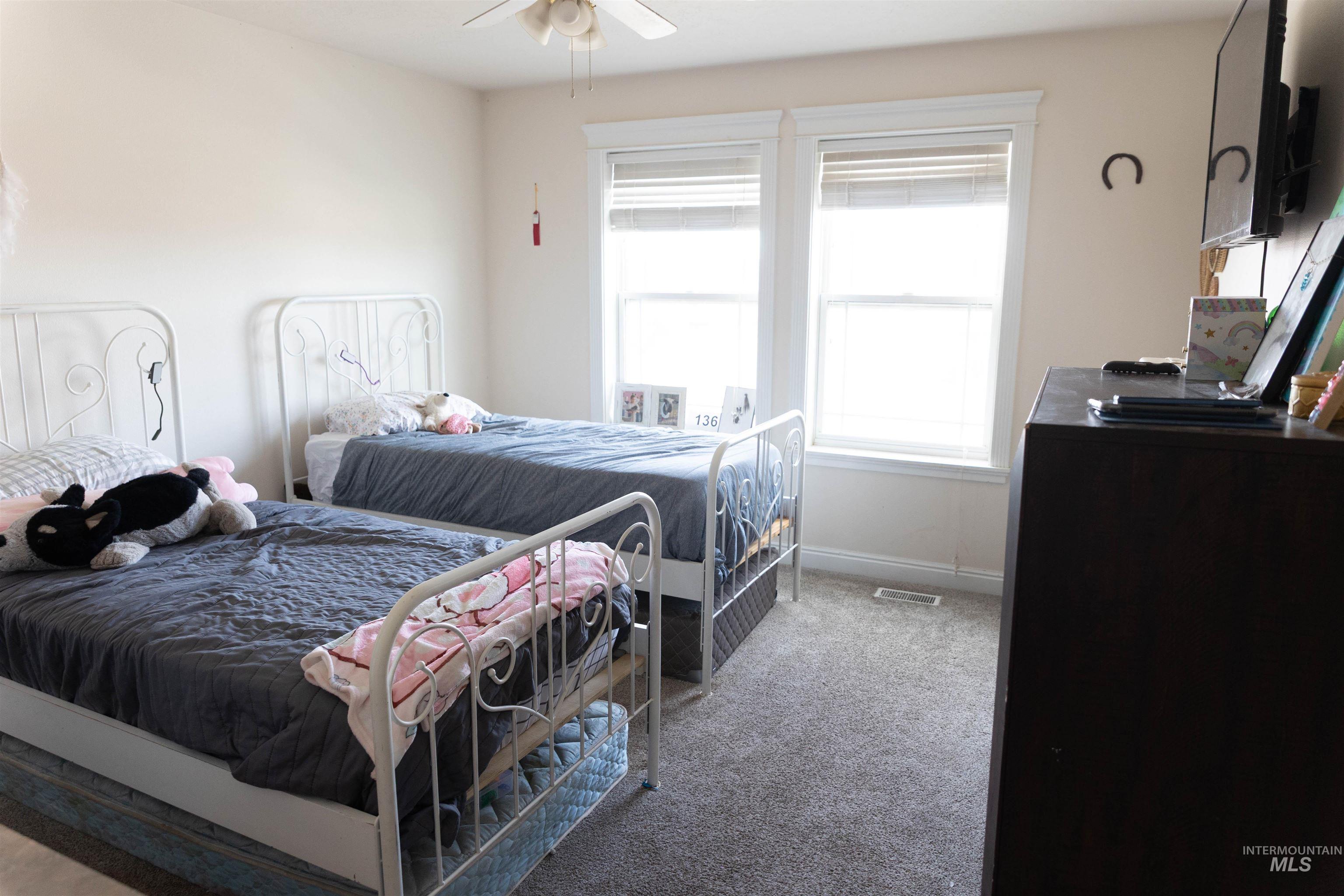 765 Southwest Foley Street Mountain Home, ID 83647 - Photo 11 of 37 Bedroom featuring light carpet and ceiling fan