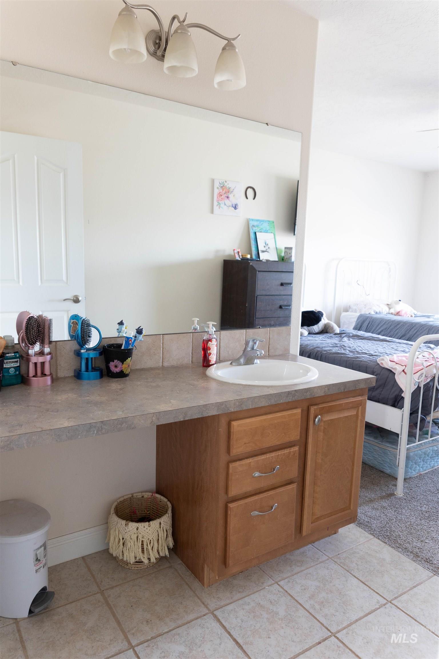 765 Southwest Foley Street Mountain Home, ID 83647 - Photo 13 of 37 Bathroom with vanity, ensuite bathroom, and light tile patterned flooring