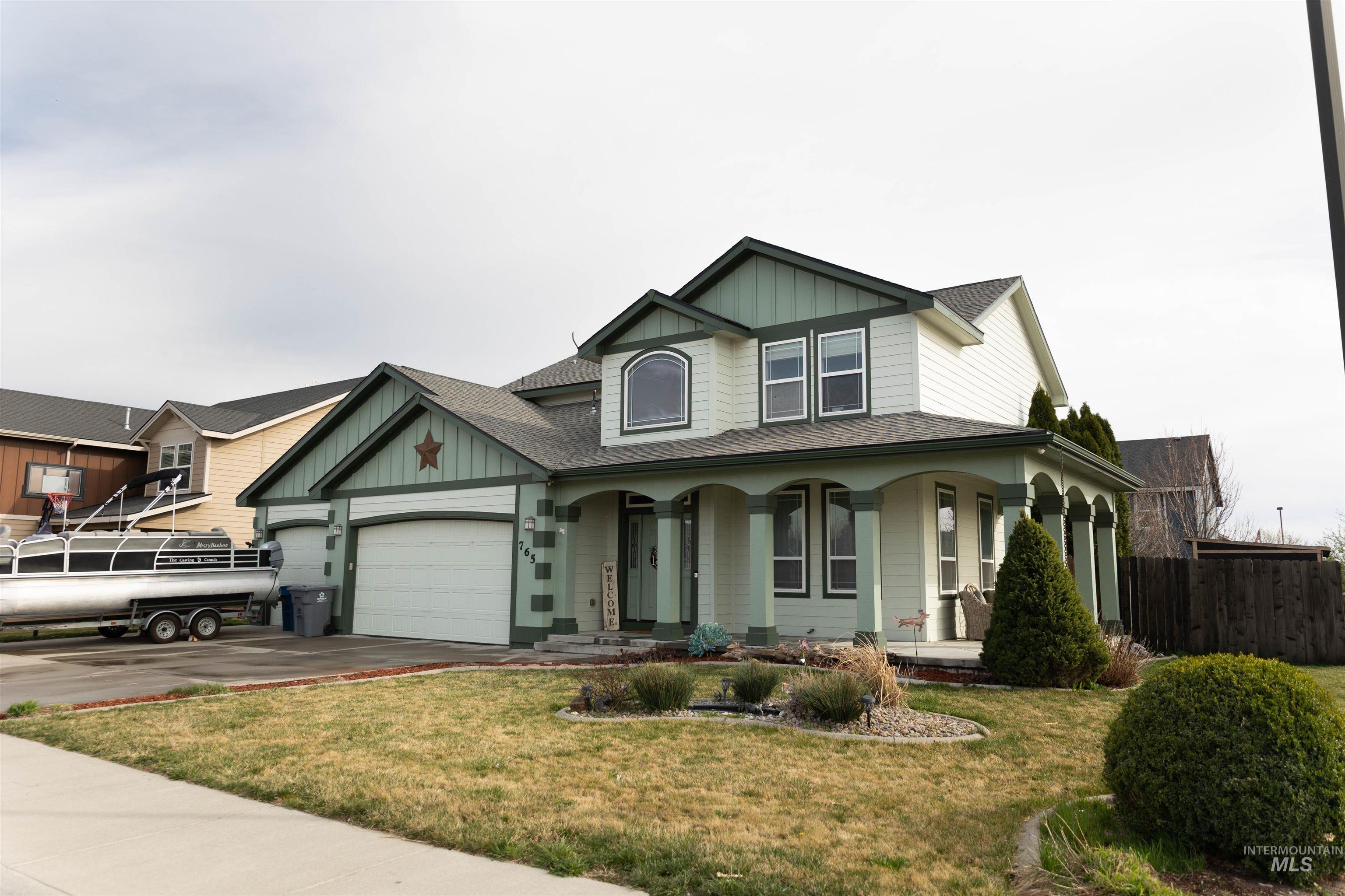 765 Southwest Foley Street Mountain Home, ID 83647 - Photo 2 of 37 View of front of house with board and batten siding, a porch, roof with shingles, an attached garage, and driveway