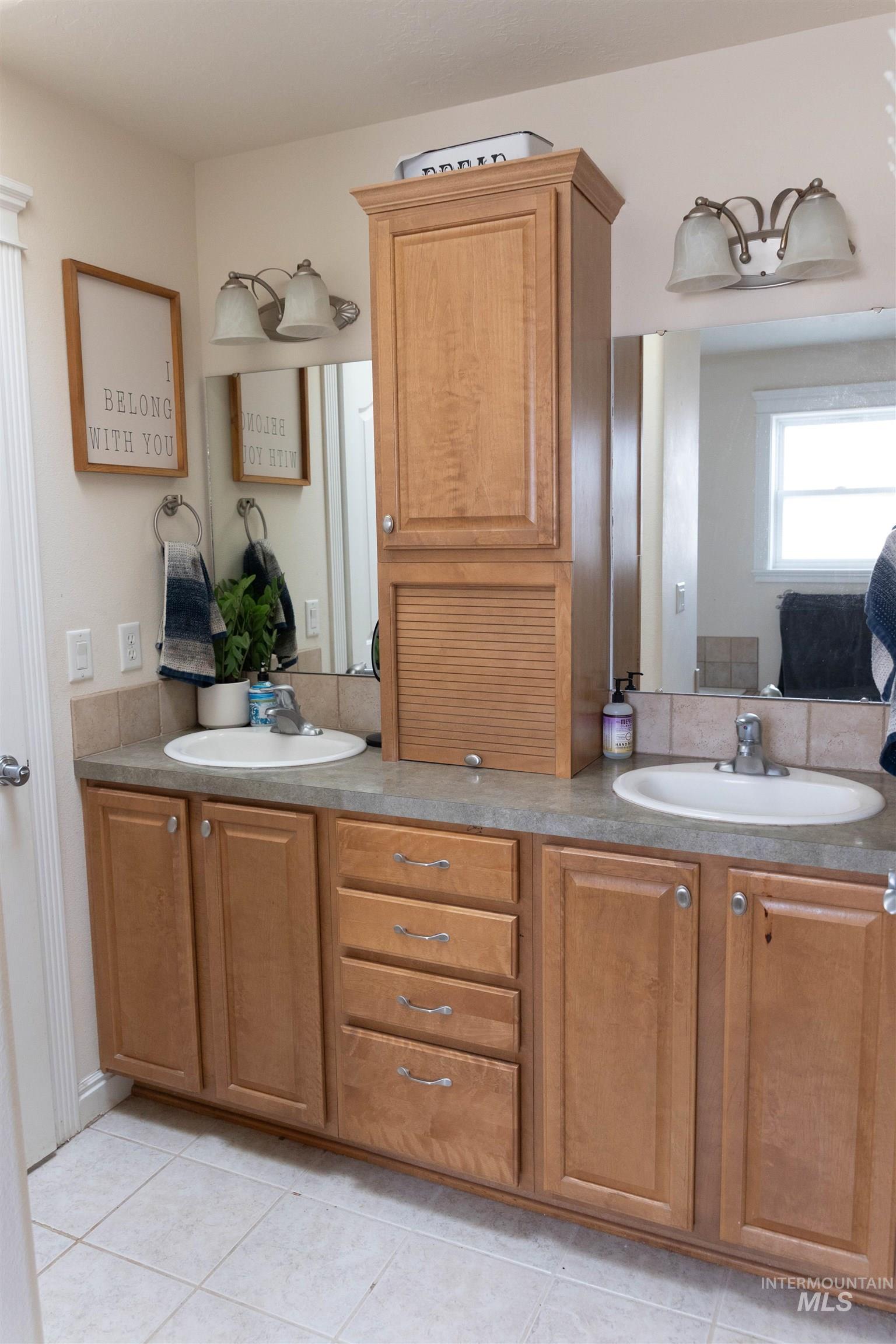 765 Southwest Foley Street Mountain Home, ID 83647 - Photo 23 of 37 Bathroom featuring double vanity, light tile patterned floors, and connected bathroom