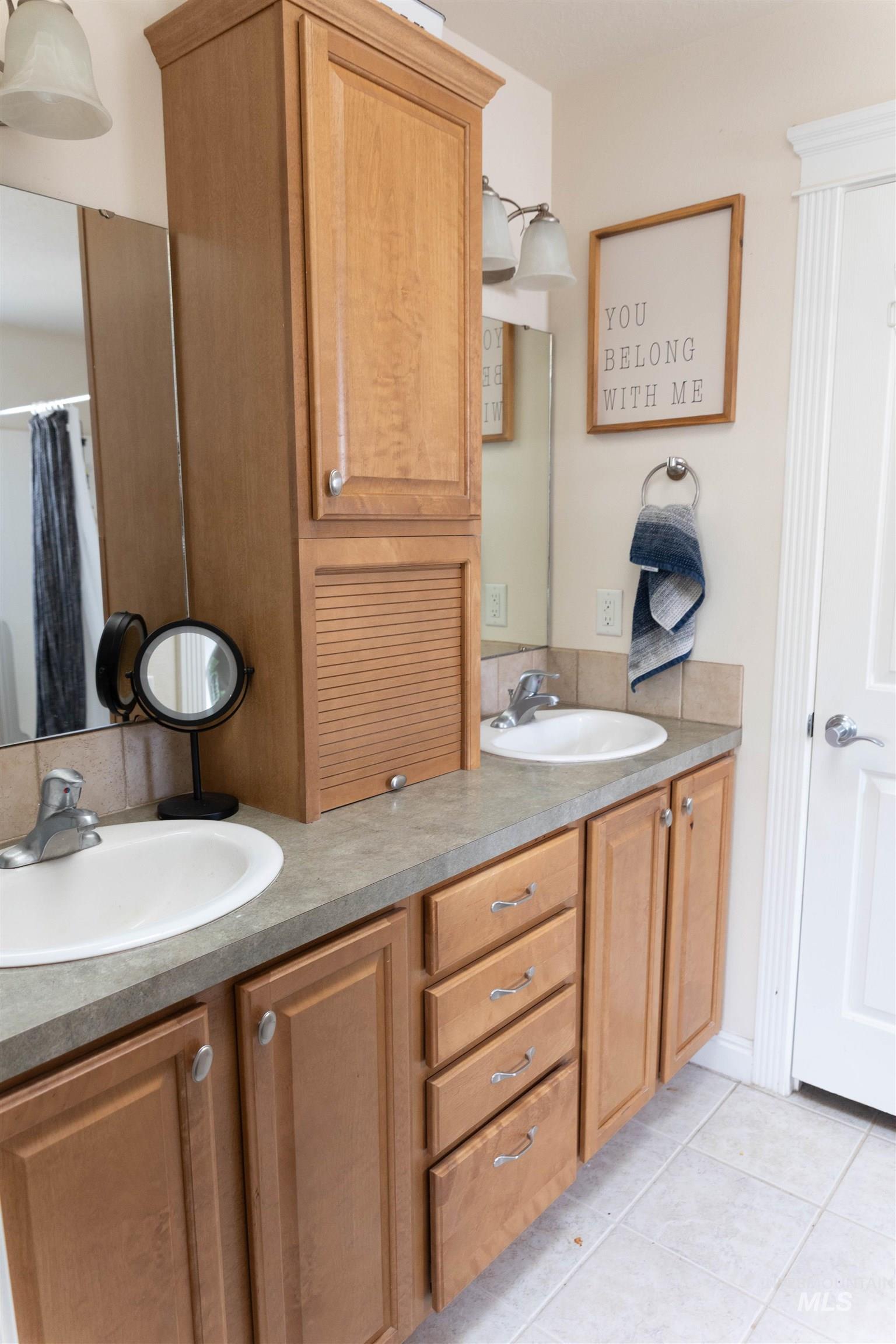 765 Southwest Foley Street Mountain Home, ID 83647 - Photo 24 of 37 Bathroom featuring double vanity, light tile patterned floors, and a shower with shower curtain
