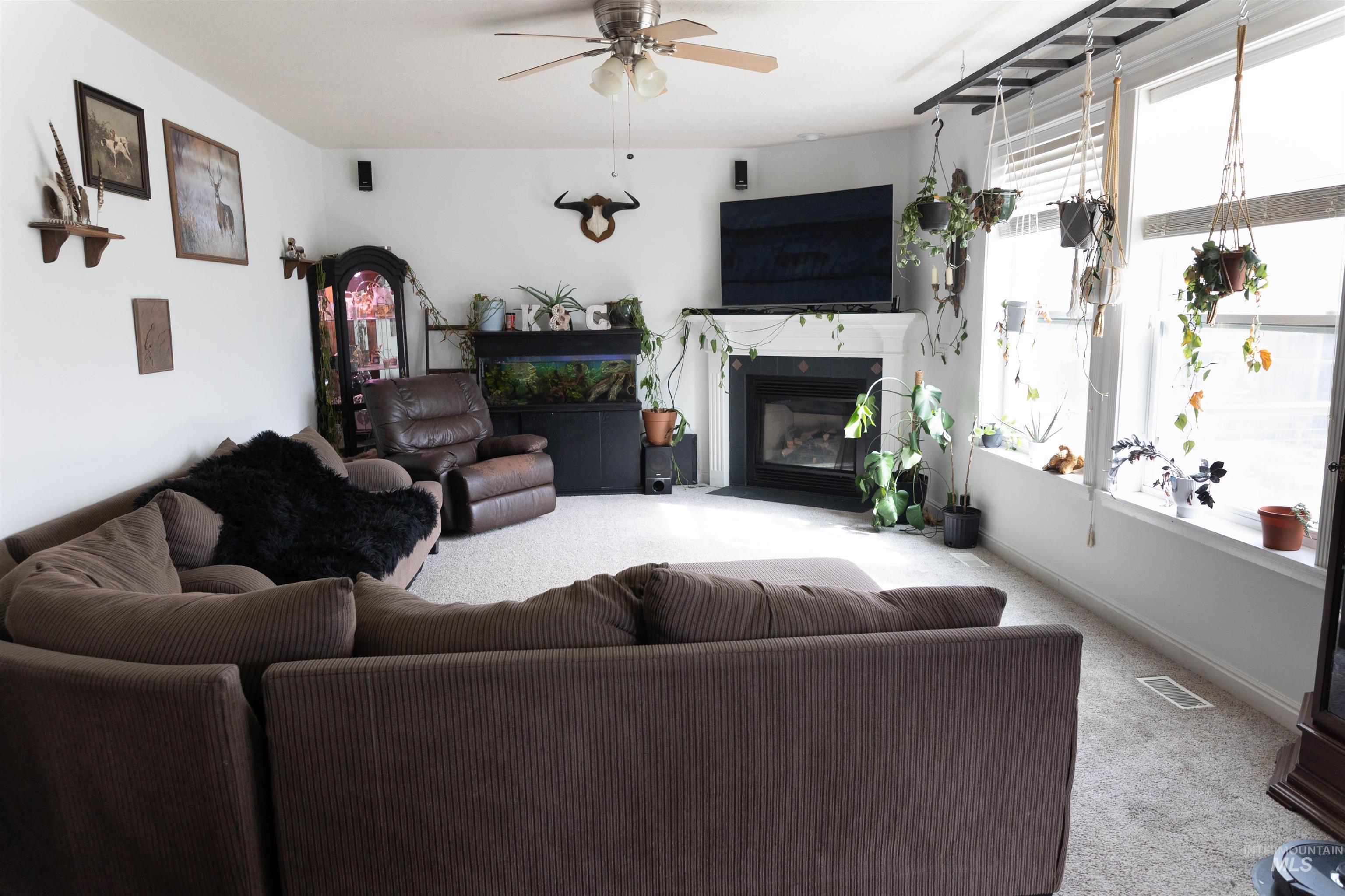 765 Southwest Foley Street Mountain Home, ID 83647 - Photo 6 of 37 Living room featuring carpet flooring, a fireplace with flush hearth, and a ceiling fan