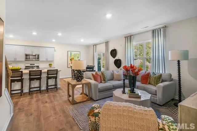 a living room with furniture kitchen and a large window