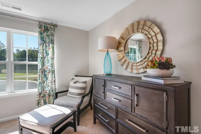 a living room with furniture a mirror and a window